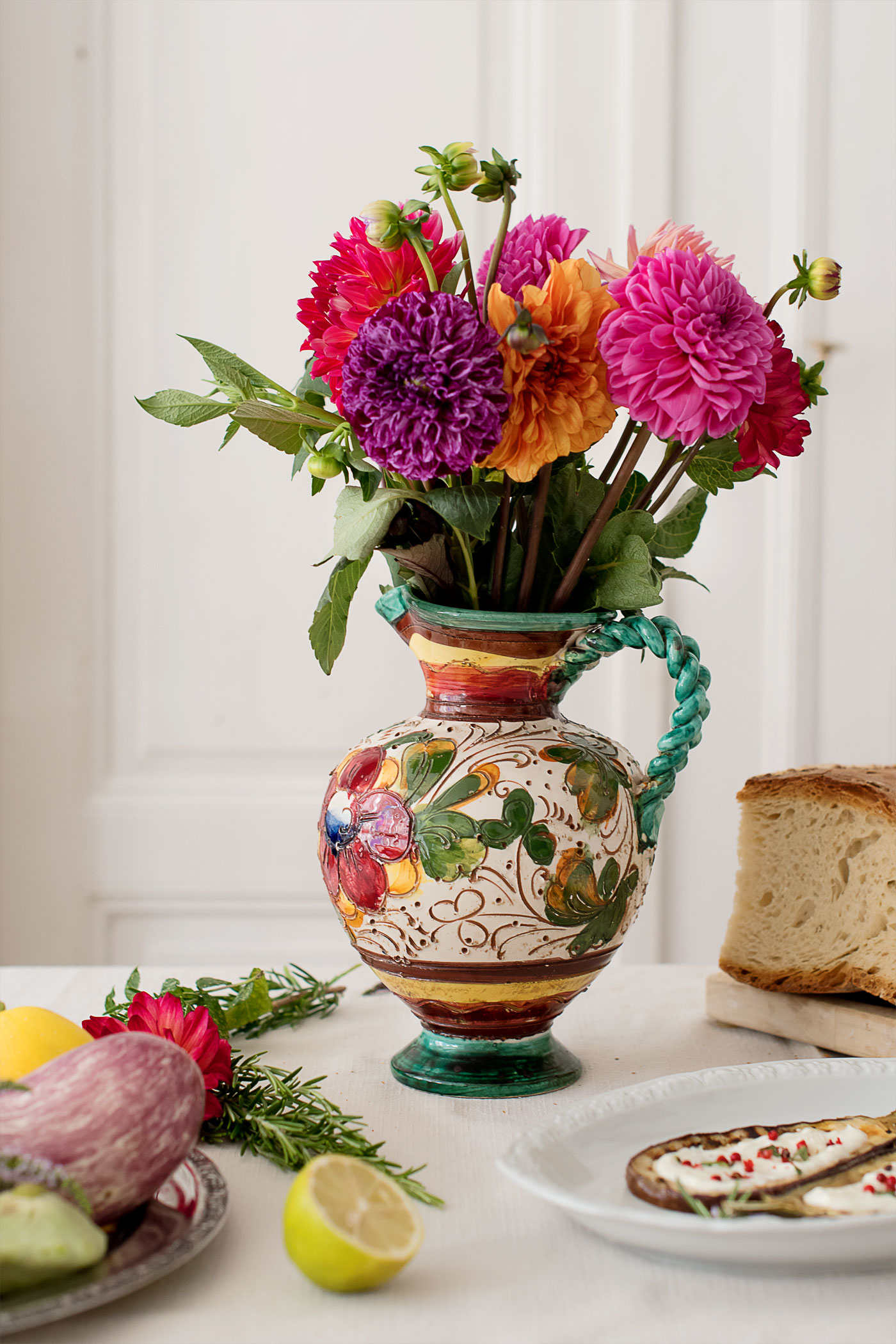 Rezeptbeitrag mit gegrillten Auberginen und Zucchinis mit einer Joghurtcreme und floraler Dekoration mit Dahlien.