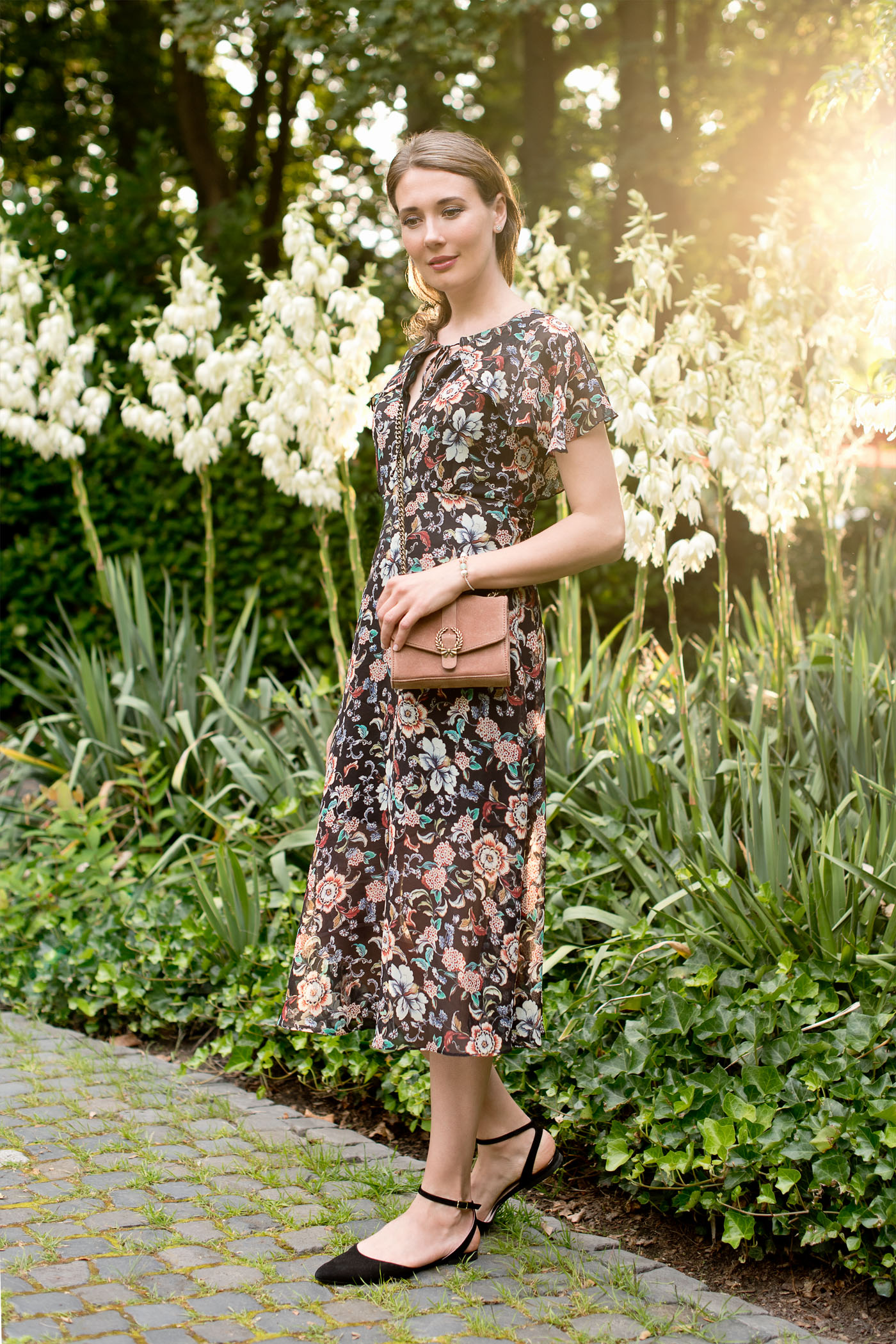 Outfitpost mit einem Kleid mit floralem Print von Zara, einer Wildledertasche von Zara, Riemchenballerinas von Unisa und Ohrstecker von Thomas Sabo, einem Karma Beads Armband von Thomas Sabo.